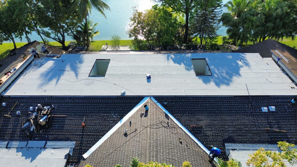 Overhead view of a white flat roof with skylights on a waterfront building
