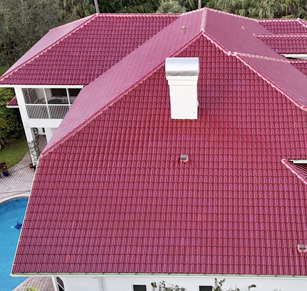 Red tile roof with a white chimney cap on a two-story home