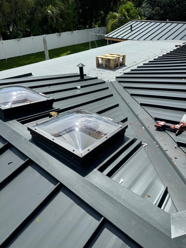 Dome skylights installed on a gray standing seam metal roof