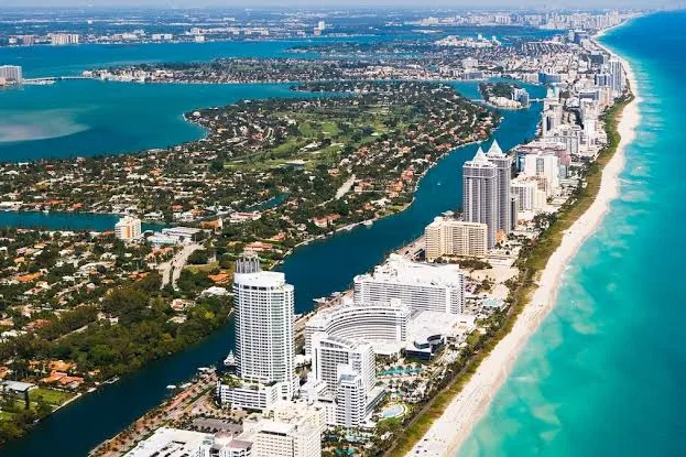 Aerial view of oceanfront high-rises, beach and bay along the Miami, FL coastline