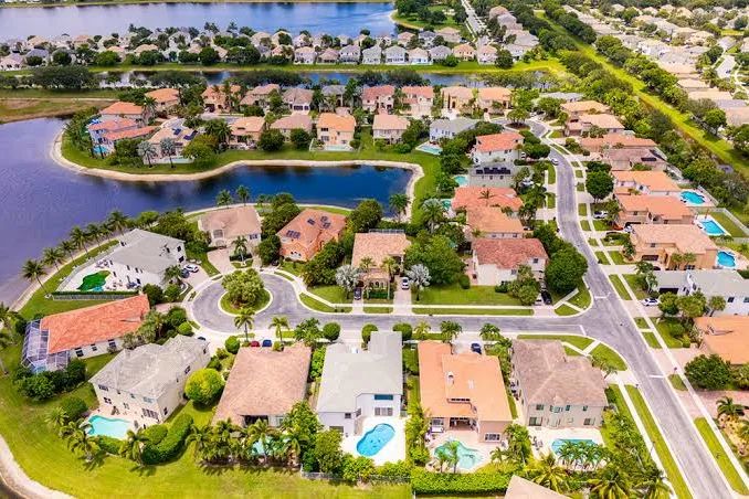 Aerial view of a lakeside neighborhood with tile-roof homes in Wellington, FL