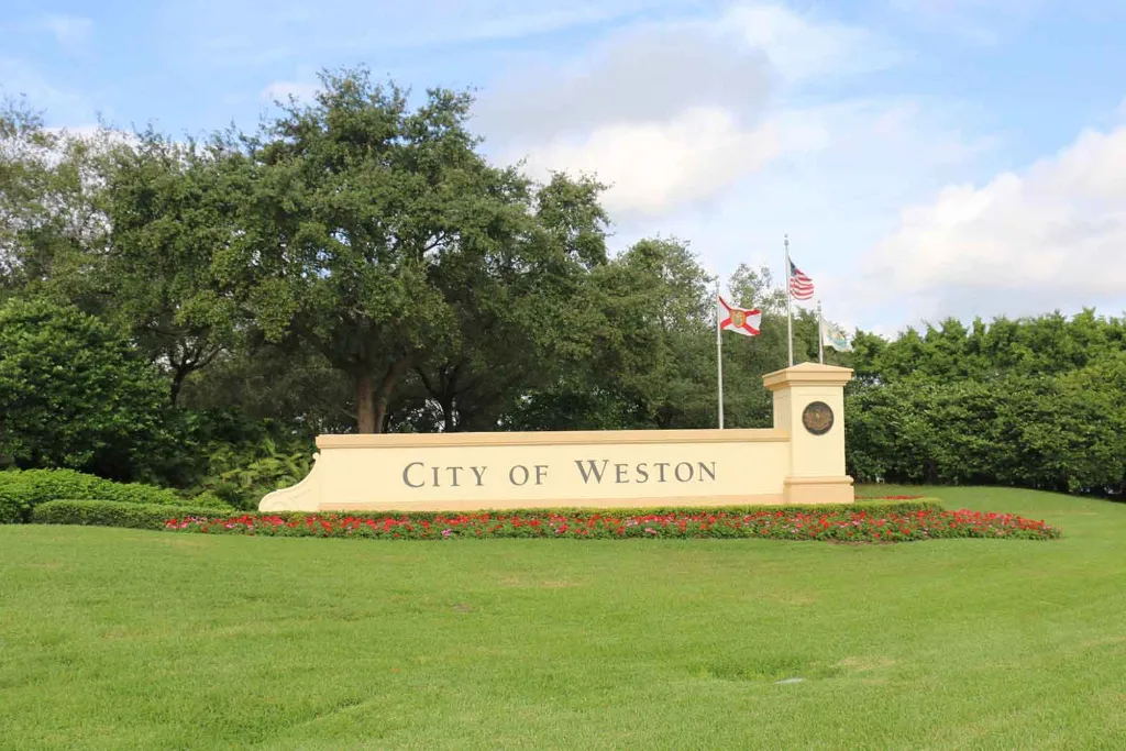 City of Weston entrance sign on a green lawn with trees